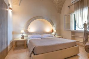 una camera da letto con un grande letto con un arco sopra di esso di VILLA Alessandra a Marina di Pescoluse