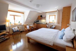 a bedroom with a large bed and a kitchen at Gästehaus am Brombachsee in Pfofeld