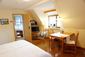 1 dormitorio con cama, mesa y escritorio en Gästehaus am Brombachsee, en Pfofeld