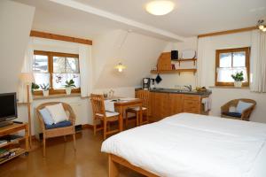 1 dormitorio con 1 cama y cocina con mesa en Gästehaus am Brombachsee, en Pfofeld