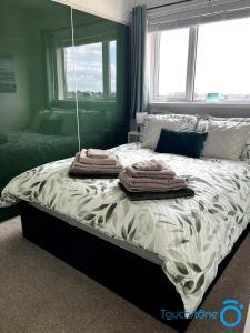 Una cama con toallas en un dormitorio en Stylish House links to B'ham, Solihull, NEC, M42, en Sheldon