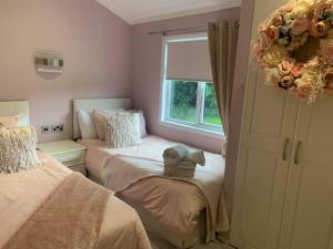a bedroom with two beds and a wreath on the window at The Lodge at Haggerston Castle in Beal