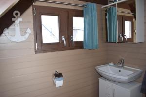 La salle de bains est pourvue d'un lavabo, de toilettes et d'un miroir. dans l'établissement Chalet im See- Nr 44, à Rust