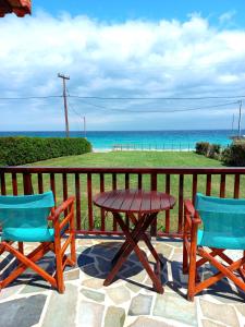 stół piknikowy i 2 krzesła na balkonie z widokiem na ocean w obiekcie Villa Dimitra w mieście Mourteri
