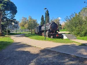 un viejo tren sentado en el césped junto a una calle en δίπλα στο πάρκο, en Kalamata