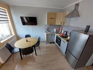 a small kitchen with a table and a refrigerator at Apartament Black Sea 2 rooms - pokoje in Świnoujście
