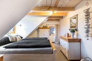 een slaapkamer met een bed en een trap bij Kamin-Haus-Nr-2-mit-Sauna-in-Burg in Fehmarn