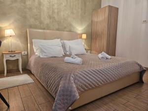 a bedroom with a bed with towels on it at Heritage Stone Wall Room & Apartment in Split