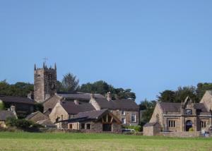 LongnorにあるLongnor Wood Holiday Parkの教会塔のある古い村