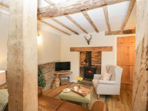 a living room with a couch and a fireplace at Pool Cottage in Hereford