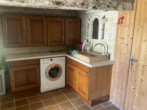 a kitchen with a washing machine and a sink at Villa de 5 chambres avec piscine privee jardin amenage et wifi a Saint Maime in Saint-Maime