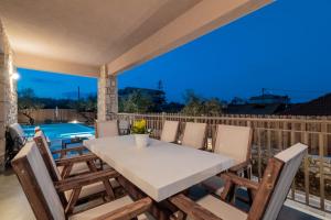 un tavolo e sedie su una terrazza con vista sulla piscina di Claudio Stone House a Vasilikós