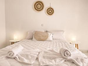 una camera da letto con un letto bianco e asciugamani di Villa Anastasia ad Apolakkiá