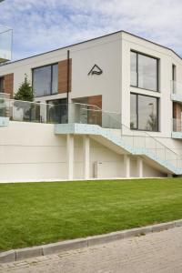 a white house with a lawn in front of it at Olimpijska by RENT4YOU in Olsztyn