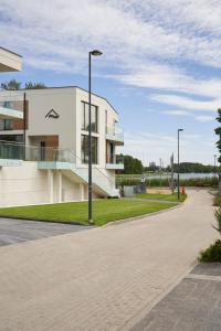 a white building with a street light next to it at Olimpijska by RENT4YOU in Olsztyn