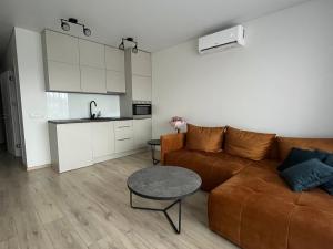 uma sala de estar com um sofá, uma mesa e uma cozinha em Mano Jūra 2, Kunigiškiai - Viltės Apartamentai em Palanga