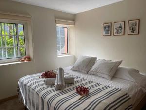 a white bedroom with a bed with flowers on it at Secluded cottage w pool, oceanside view, 3BR, 3BA in Ponta do Sol