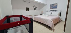 een slaapkamer met een bed en een rode stoel bij Traditional Olive House in Makry Gialos