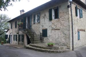 un antiguo edificio de piedra con escaleras y una escalera en Ca' Morano, en Pavullo nel Frignano