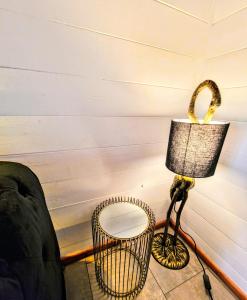 a lamp sitting next to a chair next to a wall at Magpie 2 Hot Tub HuntersMoon-Warminster-Longleat-Wiltshire in Warminster
