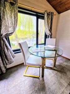 a glass table and chairs in a room with a window at Magpie 2 Hot Tub HuntersMoon-Warminster-Longleat-Wiltshire in Warminster