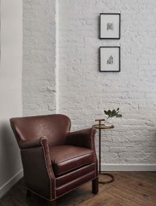 a brown leather chair in a room with a table at Walker Hotel Tribeca in New York