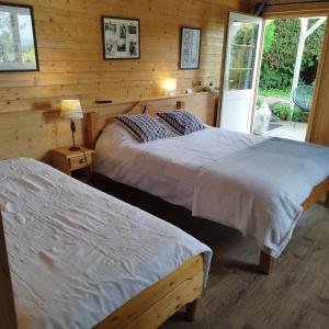 a bedroom with two beds and a sliding glass door at Chalet La Bachole in Charancieu