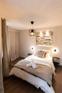 ein Schlafzimmer mit einem großen Bett und einer Steinmauer in der Unterkunft La balançoire - Résidence Hestia in Saint-Étienne
