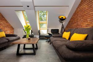 a living room with couches and a brick wall at Industrial-style 2BD Loft with Parking Spot in Plovdiv