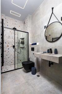 ein Bad mit einer Dusche, einem WC und einem Waschbecken in der Unterkunft Industrial-style 2BD Loft with Parking Spot in Plowdiw