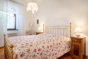 1 Schlafzimmer mit einem Bett mit Blumenbettdecke in der Unterkunft Wunderhorn in Civezzano