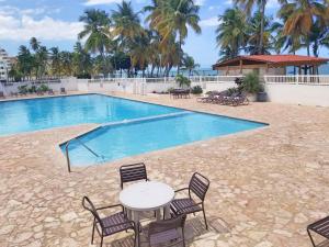 a pool with a table and chairs in front of it at Marbella del Caribe Isla Verde Beachfront in San Juan