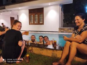 a group of people sitting around a swimming pool at Suriya Arana in Negombo