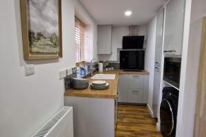eine Küche mit weißen Schränken und einer Arbeitsplatte in der Unterkunft 1 Bedroom Studio in Eltham