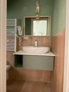 ein Bad mit einem Waschbecken und einem Spiegel in der Unterkunft La Casa di LiLù in Taranto
