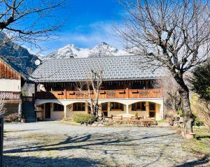 a large building with a snow covered mountain in the background at Le Catelan in La Paute