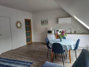 a living room with a table and chairs and a kitchen at Grand studio, tout équipé et rénové. in Combrit