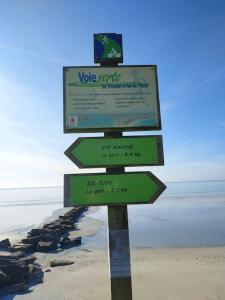 a sign on the beach next to the water at Grand studio, tout équipé et rénové. in Combrit