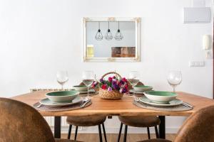 een eettafel met borden en wijnglazen bij MyHouseSpain - Acogedor piso nuevo en Gijón in Gijón