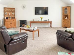 a living room with two couches and a coffee table at Leddon Farm Annexe-uk39616 in Gooseham