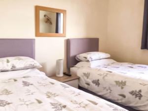 two beds sitting next to each other in a room at Leddon Farm Annexe-uk39616 in Gooseham