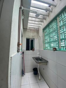 baño con lavabo y ventana en apartamento mobiliado perto das praias, en Natal