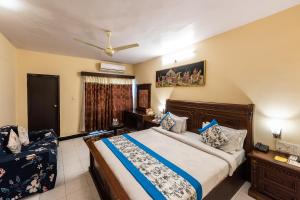 a bedroom with a large bed and a couch at Yorkshire Inn in Mount Ābu