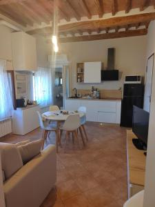 a kitchen and living room with a table and chairs at Serendipity House in Grosseto