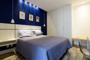 1 dormitorio con 1 cama con pared azul en Novo! DESIGN e MELHOR LOCALIZAÇÃO Copacabana PRAIA, en Río de Janeiro
