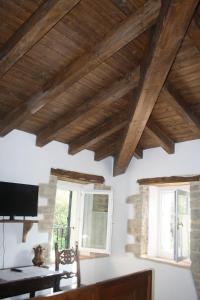 een woonkamer met houten plafonds en ramen bij Ca' Morano in Pavullo nel Frignano