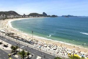una playa con mucha gente y el océano en Novo! DESIGN e MELHOR LOCALIZAÇÃO Copacabana PRAIA, en Río de Janeiro