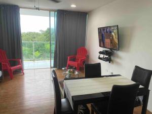 uma sala de estar com cadeiras vermelhas, uma mesa e uma televisão em Bala Beach Paradise 1-bedroom Fully Equipped apt. em Colón