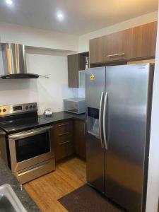 a kitchen with a stainless steel refrigerator and a stove at Bala Beach Paradise 1-bedroom Fully Equipped apt. in Colón