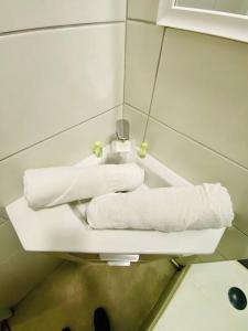 ein Badezimmer mit weißen Handtüchern auf einem Regal in der Unterkunft ''Les Grangettes'' Studio climatisé, proche plage in Sète
